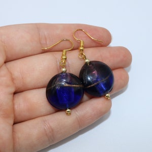 Handmade earrings with round purple and dark blue glass bead separated by a gold line