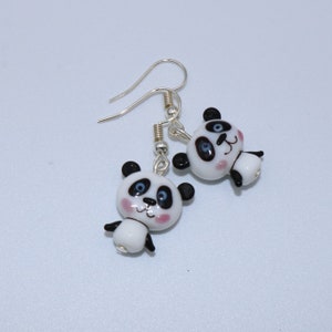 Handmade earrings in cartoon style with white and black glass bead in the shape of a panda