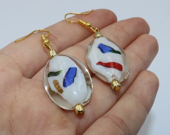 Handmade earrings of an oval glass bead with colored accents in gold, red, green, blue and orange