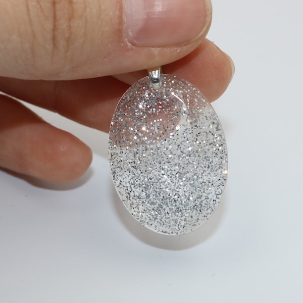 Pendentif ovale à facettes fait à la main en résine transparente aux accents brillantes en paillettes argentées