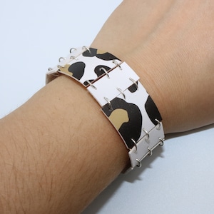 Handmade bracelet made of white, black and brown faux leather strips connected with silver stainless steel rings