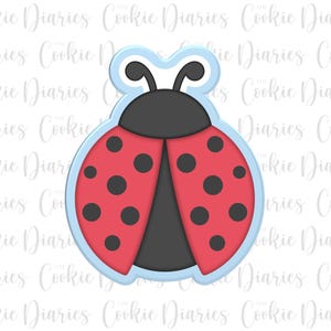 May include: A ladybug-shaped cookie cutter with a light blue outline. The ladybug has red wings with black spots, a black head, and black antennae. The text "Cookie Diaries" is in the background.