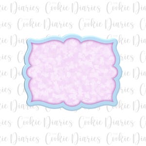 Peut inclure: Un emporte-pièce rectangulaire décoratif bleu clair et rose. L'intérieur est de couleur rose clair avec un motif moucheté. Le bord extérieur est de couleur bleu clair. Le texte "Cookie Diaries" est visible en arrière-plan.