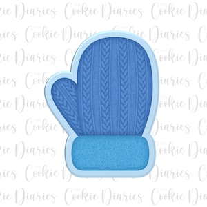 May include: A blue cookie cutter shaped like a mitten with a cable knit pattern. The mitten has a folded cuff at the top.