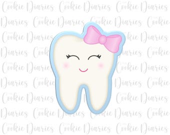 May include: A light blue tooth cookie cutter with a pink bow and a smiling face.