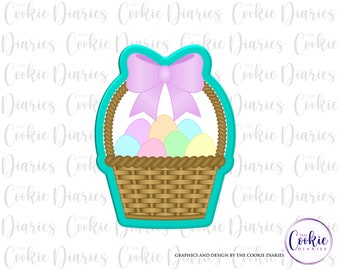 May include: A turquoise blue cookie cutter shaped like a basket with a pink bow and pastel coloured eggs inside. The cookie cutter is for making Easter cookies.