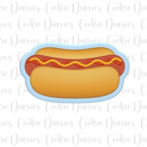 May include: A cartoon hot dog cookie cutter. The hot dog features a brown sausage, red ketchup, and yellow mustard on a yellow bun, within a light blue outline. The background has the text "Cookie Diaries".
