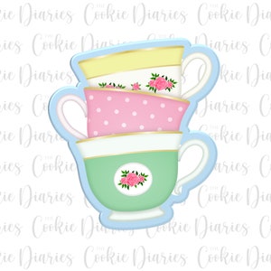 May include: A stack of three teacups with floral and polka dot patterns. The teacups are in shades of yellow, pink, and green. The teacups are stacked on top of each other and have a blue outline.