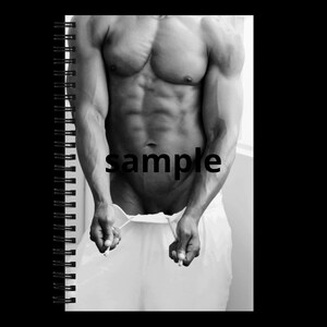 Può includere: Quaderno a spirale in bianco e nero con la parola "sample" stampata sulla pagina. L'immagine presenta una fotografia in scala di grigi di un torso e braccia muscolose.