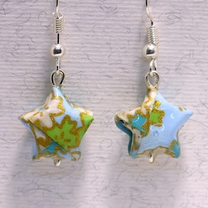 Puede incluir: Un par de pendientes de plata con abalorios de estrella origami azul, verde y dorado.