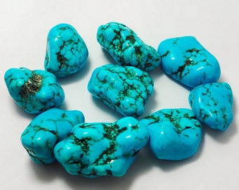 May include: A collection of nine turquoise stones, each with a unique shape and pattern of blue and green veins. The stones are smooth and polished, with a natural, earthy look.