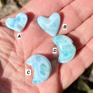 May include: Four polished blue and white heart and crescent moon shaped stones. The stones are labeled A, B, C, and D.