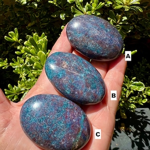 May include: Three smooth, oval-shaped stones with a blue and red marbled pattern. The stones are labeled A, B, and C.