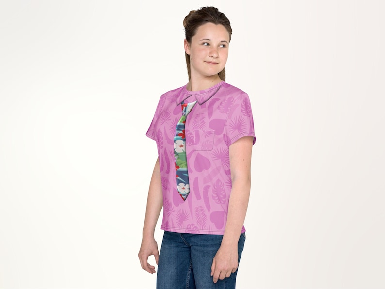 A young woman wearing a pink shirt with a tie pattern and smiling at the camera.