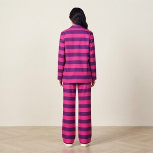 A person wearing a pink and purple striped suit stands facing away from the camera.
