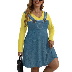 May include: A yellow long-sleeved shirt with a denim overall dress print. The dress has a V-neck and two large buttons on the straps.