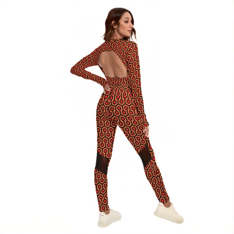 A woman wearing a long-sleeved jumpsuit with a cutout back, posing with her back to the camera.
