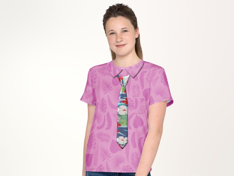 A young woman wearing a pink shirt with a tie printed on it, smiling at the camera.