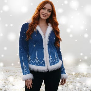 May include: A blue jacket with white faux fur trim and a starry design. The jacket has a white design on the front and sleeves. The model is wearing black trousers. The jacket is a winter-themed outerwear.