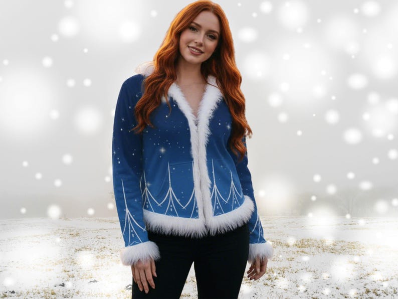 May include: A blue jacket with white faux fur trim and a starry design. The jacket has a white design on the front and sleeves. The model is wearing black trousers. The jacket is a winter-themed outerwear.