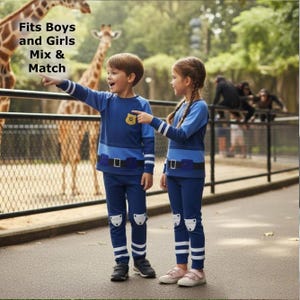 Könnte beinhalten: Zwei Kinder in passenden blauen Outfits mit Polizeiausweis-Design, die vor einer Zooausstellung stehen. Die Outfits umfassen langärmlige Hemden und Hosen mit weißen Streifen und Knieschonern. Der Text auf dem Bild lautet: Fits Boys and Girls Mix & Match.