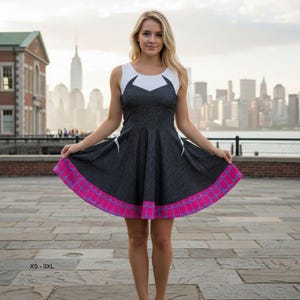 May include: A sleeveless dress with a white top and a black and white checkered skirt. The skirt has a pink and blue patterned hem. The dress is shown in front of a city skyline.
