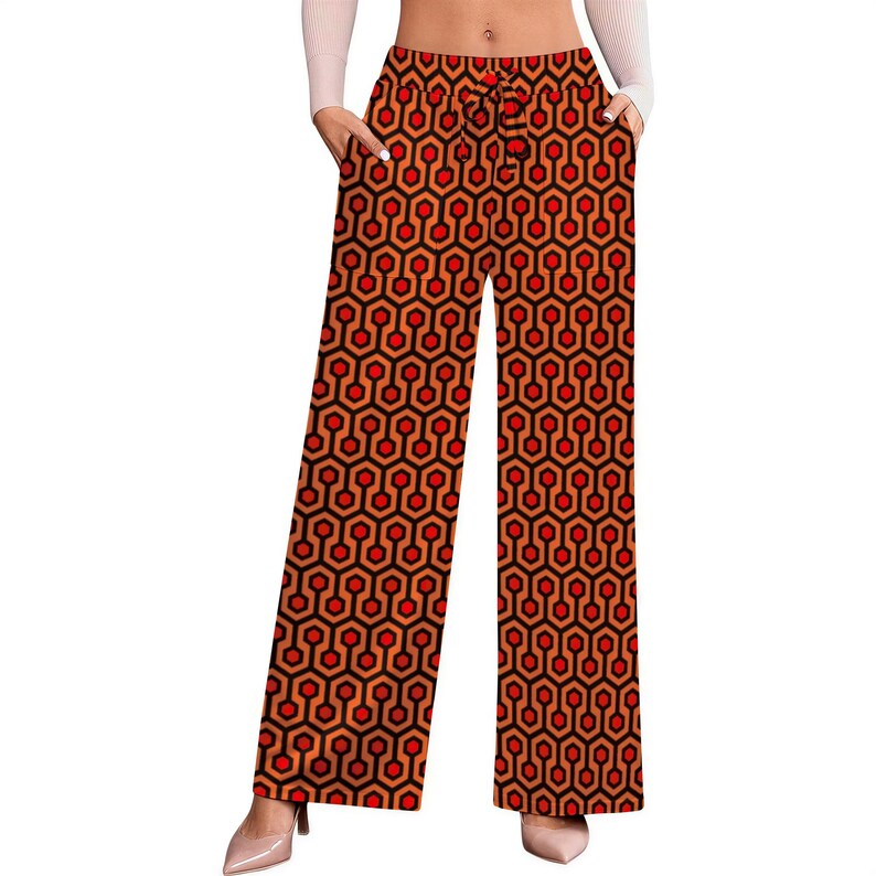 A pair of wide-leg pants with a geometric pattern in red and orange colors.