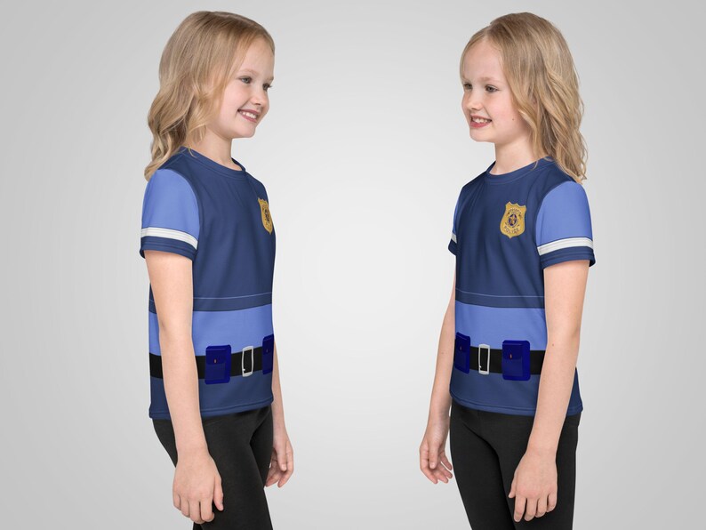 Puede incluir: Dos camisetas infantiles dise&ntilde;adas para parecer un uniforme de polic&iacute;a. Las camisetas son principalmente azul marino con detalles en azul claro, una insignia dorada y un dise&ntilde;o de cintur&oacute;n negro con bolsas azules. Las mangas tienen rayas blancas.