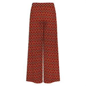 A pair of wide-leg pants with a repeating geometric pattern in shades of red and orange.