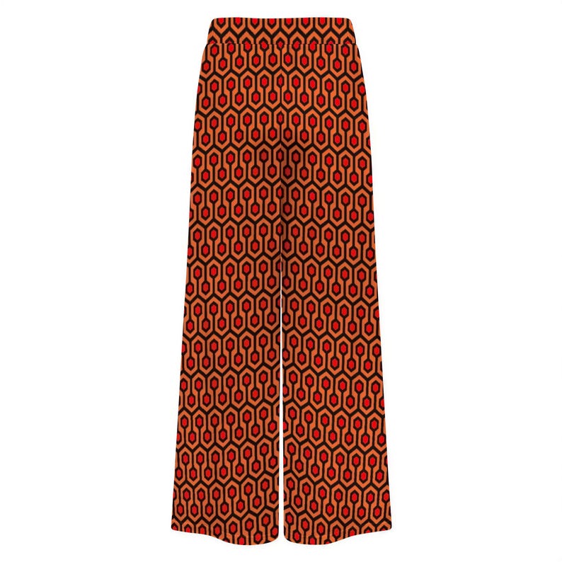 A pair of wide-leg pants with a repeating geometric pattern in shades of red and orange.