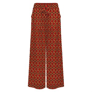 A pair of wide-leg pants with a repeating geometric pattern in shades of red and orange.