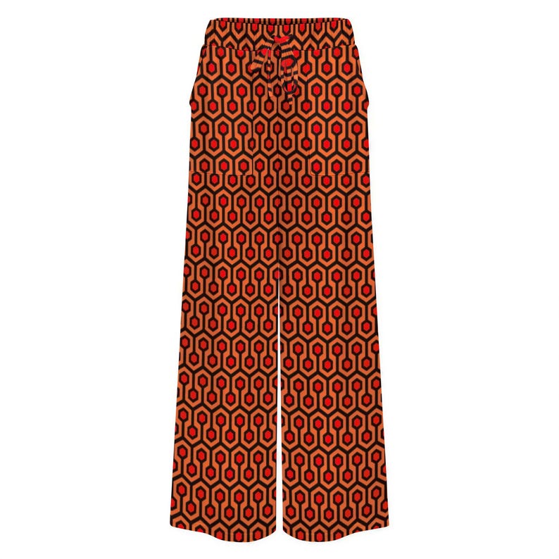 A pair of wide-leg pants with a repeating geometric pattern in shades of red and orange.