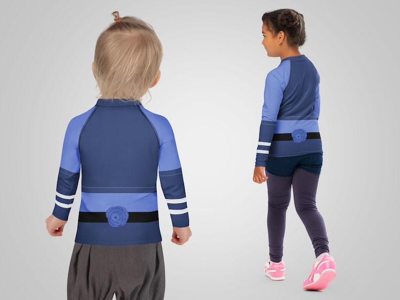 Puede incluir: Dos ni&ntilde;os con camisetas de manga larga y leggings. Las camisetas son principalmente azul marino con detalles en azul claro, un detalle de cintur&oacute;n negro y un adorno floral. Los leggings son de color gris oscuro. Un ni&ntilde;o lleva zapatillas rosas.