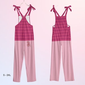 Op de afbeelding: Roze en rood gestreepte overalls met een roze varken ontwerp op de rug. De overalls hebben verstelbare banden met strikken. De maatrange is S-2XL.