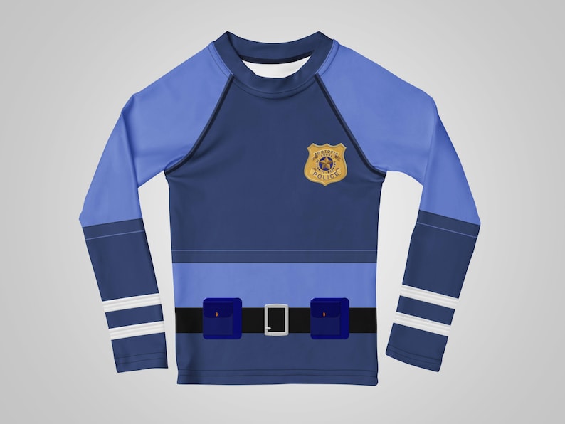 Puede incluir: Una camisa azul de manga larga dise&ntilde;ada para parecerse a un uniforme de polic&iacute;a. La camisa presenta una insignia, un cintur&oacute;n negro con hebilla plateada y dos bolsillos cuadrados azules. Las mangas tienen paneles azul claro y rayas blancas.