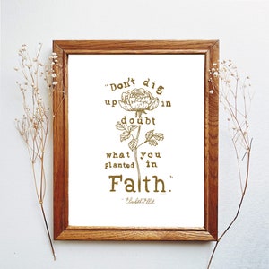 May include: A framed print with a gold floral illustration and a quote that reads "Don't dig up doubt in what you planted in Faith." - Elizabeth Elliot