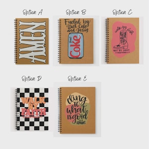 May include: Spiral-bound notebooks with various designs. Options include "AMEN" in bold letters, a Diet Coke can with "Fueled by Diet Coked and Jesus", a pink boot with "Walk by Faith", a checkered design with "Walk by Faith", and "Cling to what is good."