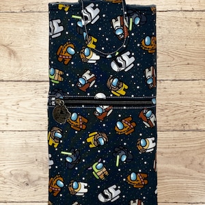 May include: A black zippered pouch with a Star Wars and Among Us character print. The pouch has a flap closure and a zippered pocket on the front.