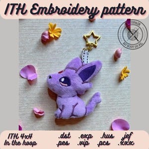 May include: A plush purple creature keychain with large dark eyes and a red forehead gem, attached to a gold star-shaped clasp. The image includes the text ITH Embroidery pattern, ITH 4x4 In the hoop, and file formats .dst .exp .hus .jef .pes .vip .pcs .xxx.