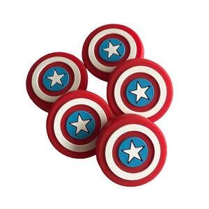 May include: Six red, white, and blue plastic Captain America shield-shaped buttons. Each button features a white star on a blue circle in the center of the shield.