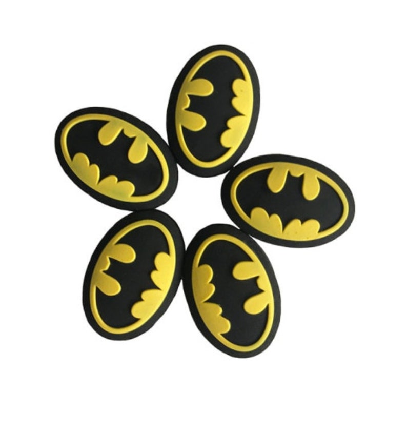 May include: Six black and gold Batman logo rubber stickers.