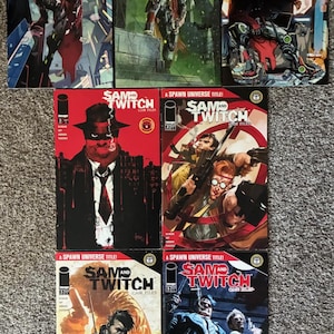 May include: A collection of comic books featuring the titles "Rat City" and "Sam and Twitch." The "Rat City" comics showcase futuristic characters in action poses. The "Sam and Twitch" comics feature illustrations of detectives and action scenes. The comics are displayed on a neutral surface.