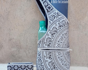 May include: A black and white yoga mat bag with a matching small pouch. The bag features a mandala design with elephants and floral patterns. A blue yoga mat and a green water bottle are visible inside the bag. The text "Yoga Mat & Bottle Not Included" is printed on the yoga mat.