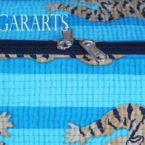 Puede incluir: Primer plano de una cremallera en una bolsa de tela a rayas azules y marrones con estampado de tigre. La cremallera es plateada y tiene un tirador negro. El texto "NEELGARARTS" es visible en la parte superior de la imagen.