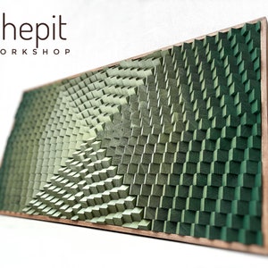 Könnte beinhalten: Holzwandkunst mit einem geometrischen Design aus kleinen, quadratischen Blöcken in verschiedenen Grüntönen. Das Kunstwerk hat einen Farbverlauf, der von hell- zu dunkelgrün übergeht. Es ist mit einem Rahmen aus Naturholz versehen und trägt den Text "shepit WORKSHOP".