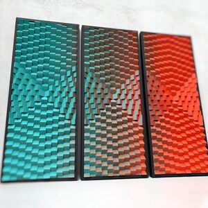 Peut inclure: Trois panneaux d'art mural rectangulaires avec un motif de cubes en 3D. Les panneaux présentent un dégradé de couleurs, notamment le teal, le marron et le rouge. Chaque panneau est encadré en noir, créant une esthétique moderne.