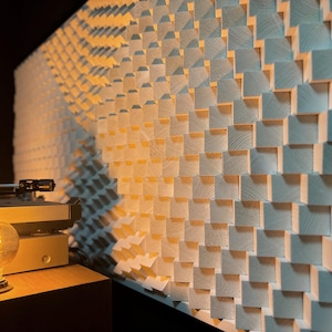 May include: A wooden wall panel with a repeating pattern of square blocks, creating a textured surface. The panel is lit with warm light, and a vintage record player and a glowing Edison bulb are in the foreground.