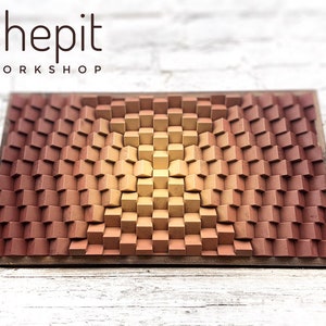 May include: A wooden wall art piece with a 3D design of squares in shades of brown and yellow. The squares are arranged in a pattern that creates a wave-like effect. The piece is framed in a dark wood frame. The text "shepit WORKSHOP" is printed at the top of the frame.