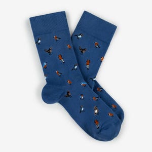 May include: A pair of blue socks with a pattern of various birds in shades of brown, orange, and blue. The socks have a ribbed cuff and are made of a soft material.