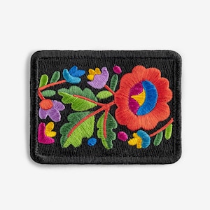 May include: A black embroidered patch with a colorful floral design. The flowers are red, orange, yellow, green, blue, and purple. The patch is surrounded by a black border.